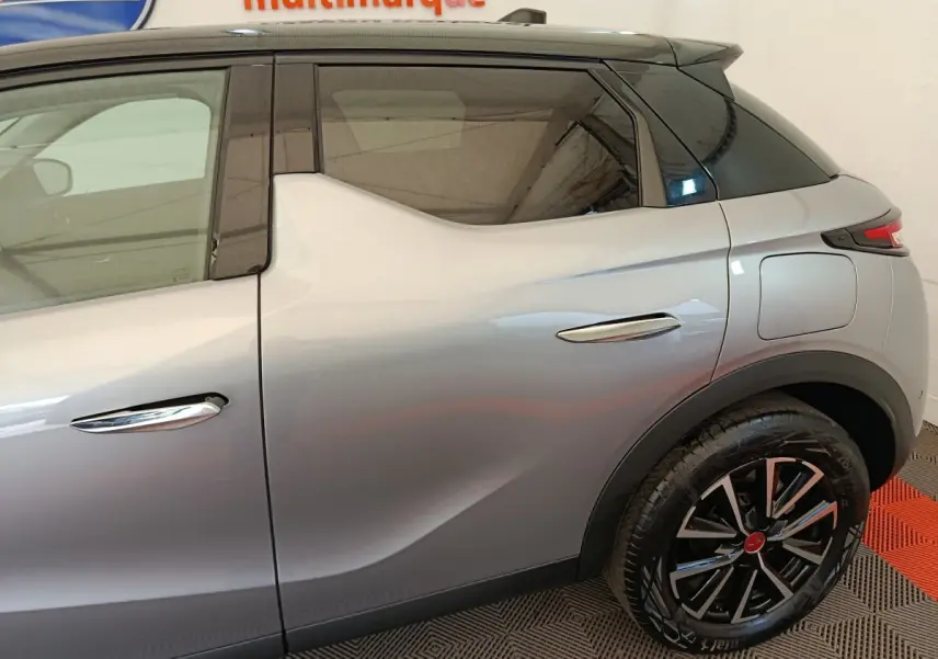 Vue latérale droite d'une DS3 gris foncé avec toit noir et jantes alliage distinctives.