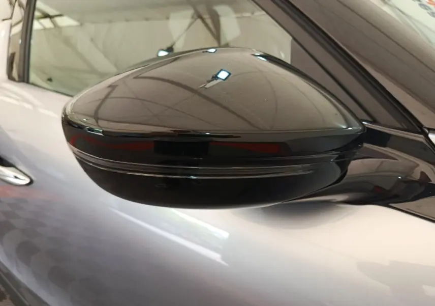 Gros plan sur le rétroviseur noir côté gauche d'une DS3 gris foncé 2024 avec clignotant intégré.