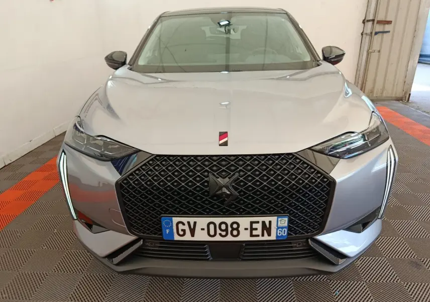 Vue frontale d'une DS3 2024 gris foncé avec calandre noire à motif losange et feux LED verticaux distinctifs.