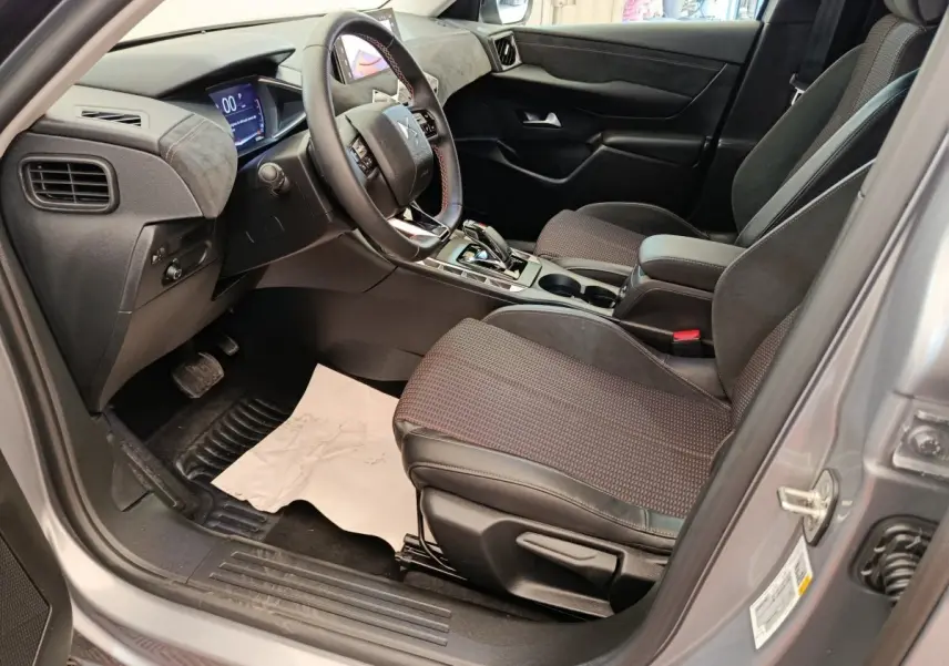 Vue intérieure côté conducteur de la DS3 2024 gris foncé, avec volant cuir multifonctions et écran digital tactile.