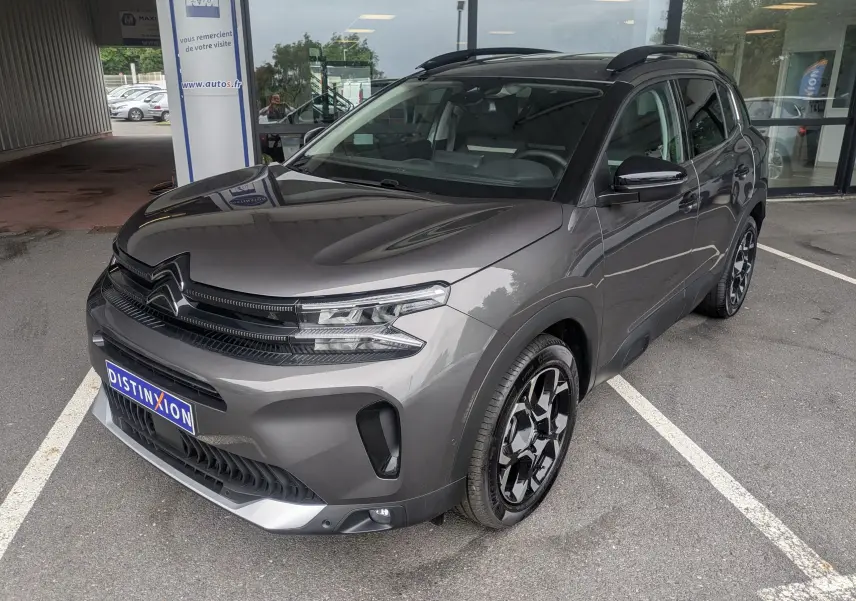 Vue 3/4 avant droite du Citroën C5 Aircross hybride gris platinium avec jantes biton 18 pouces et toit panoramique.