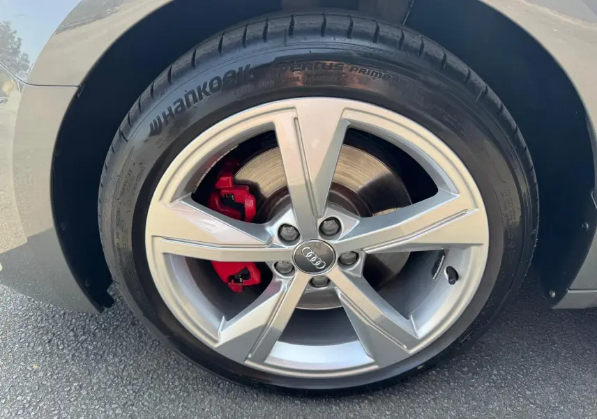 Gros plan sur la roue avant gauche grise d'une Audi A1 Sportback 2019 avec étrier de frein rouge et jante alu cinq branches.