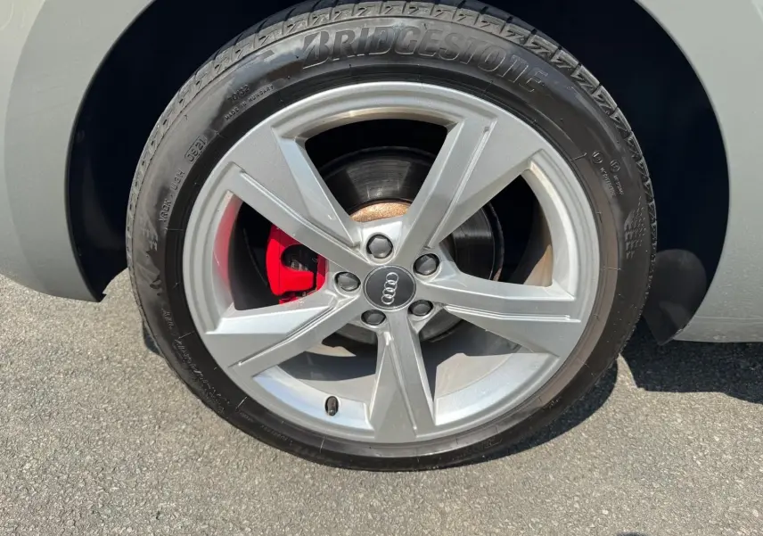 Gros plan sur la roue avant droite grise d'une Audi A1 Sportback 2019 avec étrier de frein rouge visible.
