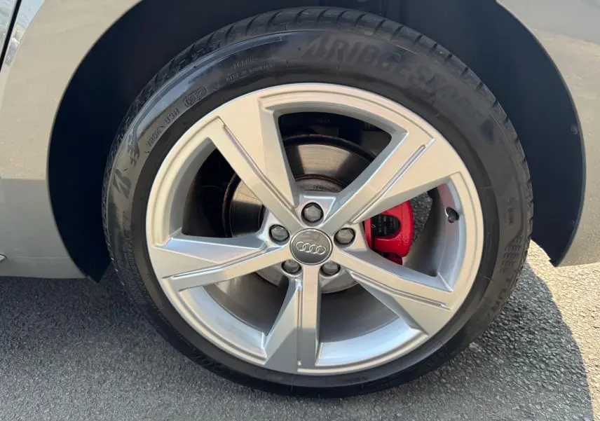 Gros plan sur la roue avant droite grise d'une Audi A1 Sportback 2019 avec étrier de frein rouge et jante alu cinq branches.