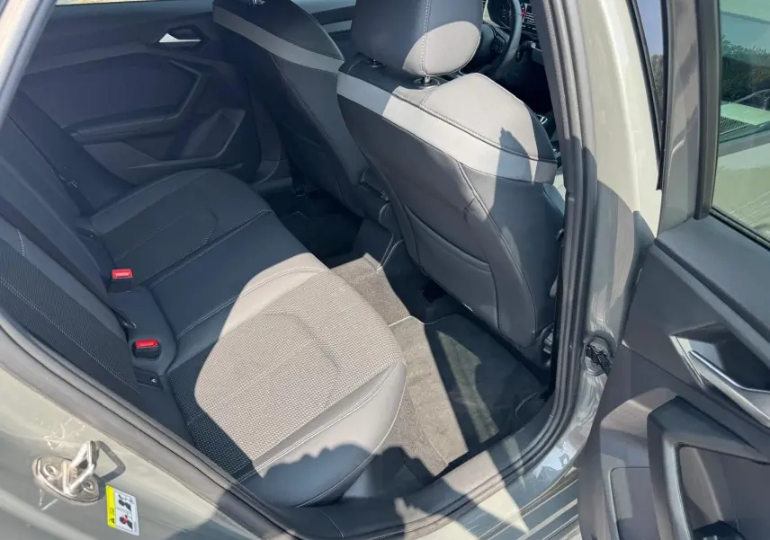 Vue intérieure côté arrière droit d'une Audi A1 Sportback gris avec sièges arrière en cuir et tissu gris.