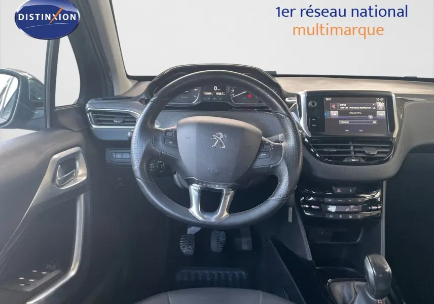 Vue intérieure centrée sur le volant et tableau de bord du Peugeot 2008 gris platinium, avec écran tactile et commandes au volant.