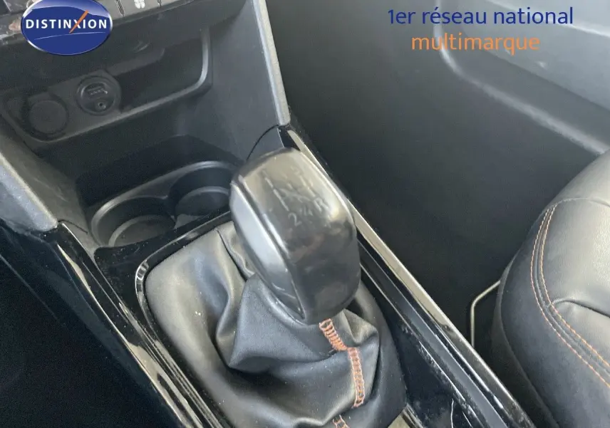 Gros plan sur le levier de vitesse manuel noir avec coutures marron à l'intérieur d'une Peugeot 2008 gris platinium.