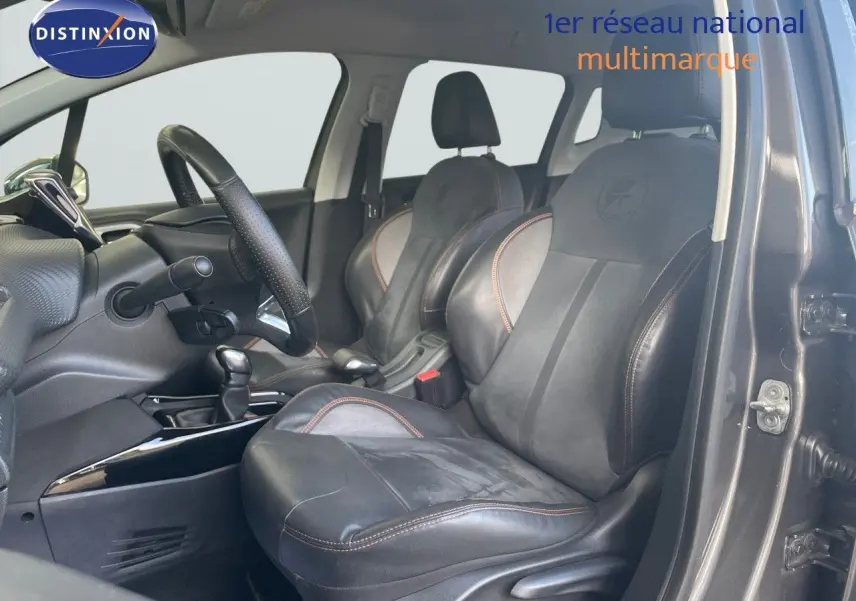 Vue intérieure côté conducteur du Peugeot 2008 gris platinium, mettant en valeur les sièges en cuir noir avec surpiqûres marron.