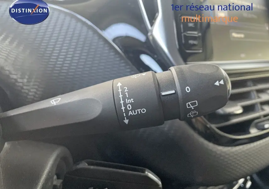Gros plan sur la commande d’essuie-glace à gauche du volant dans l’habitacle d’un Peugeot 2008 gris platinium.