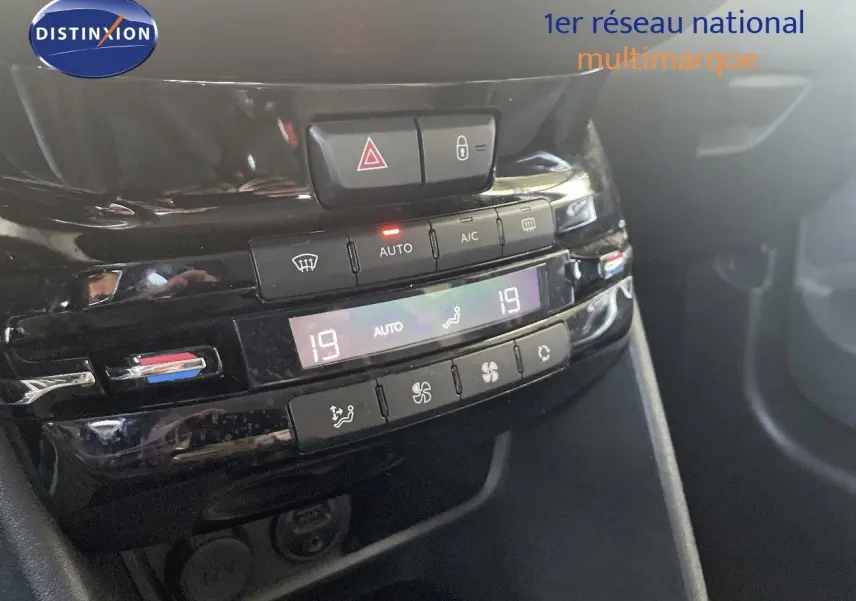 Gros plan sur la console centrale noire brillante du Peugeot 2008, affichant la climatisation automatique à 19°C.