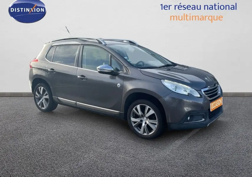 Peugeot 2008 gris platinium métal en 3/4 avant droit, avec jantes alliage bi-ton et barres de toit visibles.