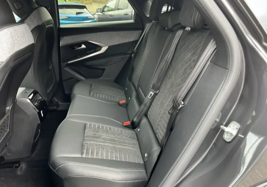 Vue côté droit de la banquette arrière en cuir alcantara gris foncé du Peugeot 3008 Hybrid 145 GT avec ceinture noire.
