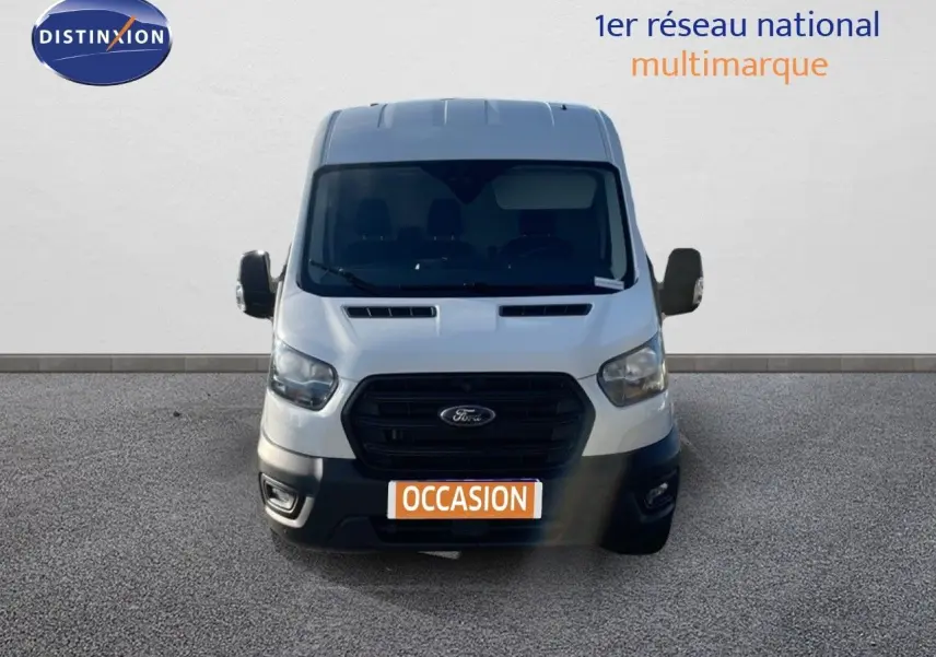 Vue frontale d'un fourgon Ford Transit blanc 2023 avec calandre noire et plaque "OCCASION" visible.