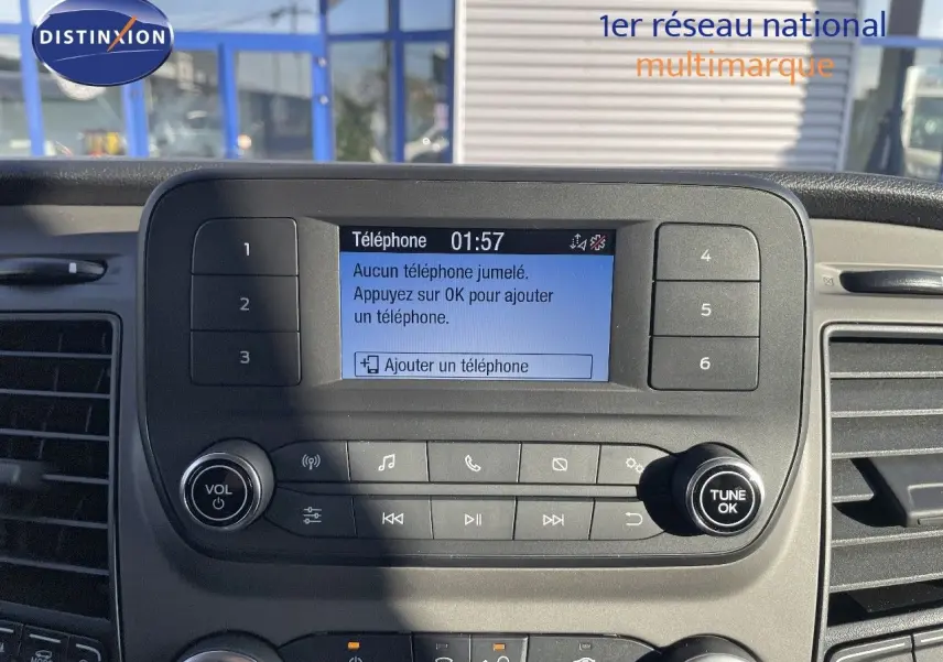 Vue rapprochée du tableau de bord noir du Ford Transit Fourgon blanc, avec écran central affichant le menu téléphone.