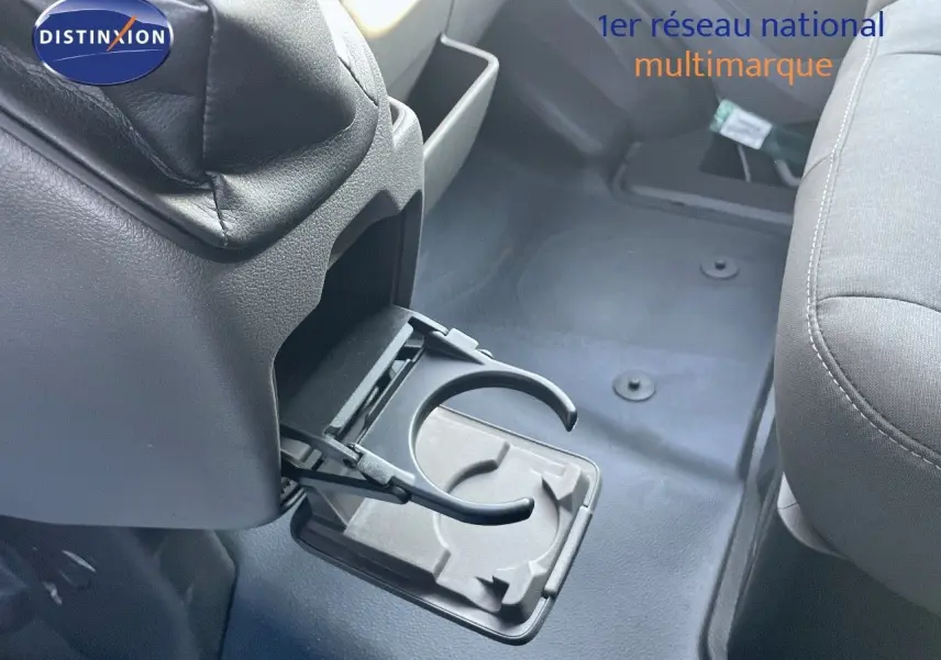 Détail de porte-gobelet déployé entre les sièges avant du Ford Transit Fourgon blanc, intérieur gris.