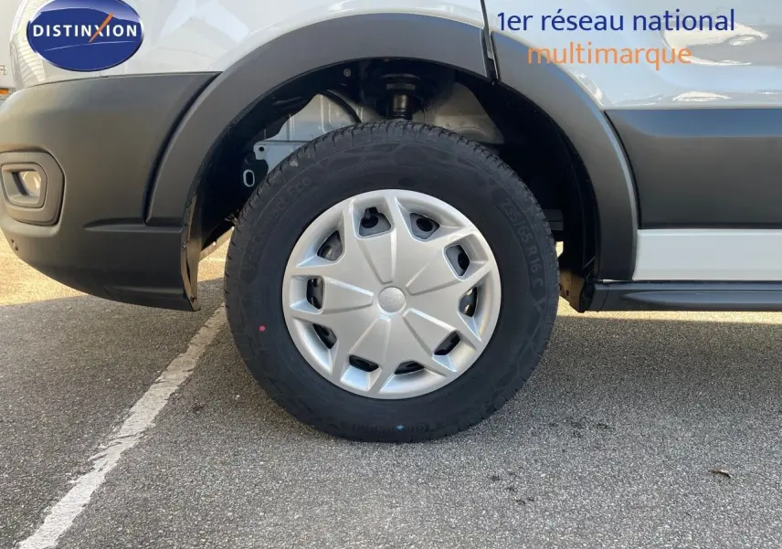 Gros plan sur la roue avant gauche du Ford Transit Fourgon blanc, mettant en valeur la jante et le passage de roue.