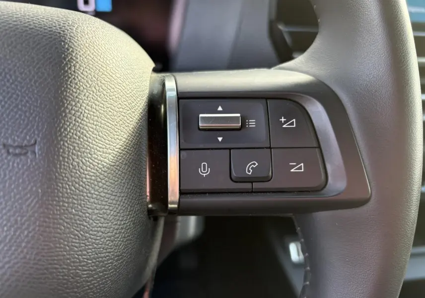 Gros plan sur les commandes audio et téléphone au volant cuir gris du Citroën C4 PureTech 130 2024.