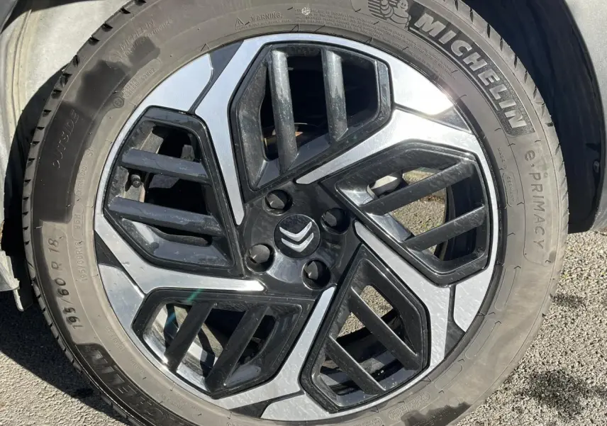 Gros plan sur la jante alliage 18'' diamantée noire et argentée d'une Citroën C4 Gris Platinium, pneu Michelin visible.