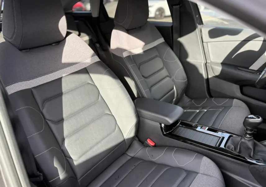 Vue intérieure des sièges avant gris et noir de la Citroën C4 PureTech 130 avec console centrale et levier de vitesses manuel.