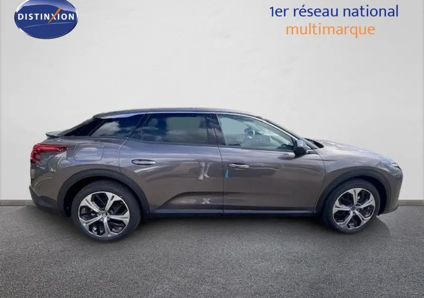 Vue de profil côté gauche d'une Citroën C5 X gris platinium métallisé avec jantes bi-ton et toit noir.