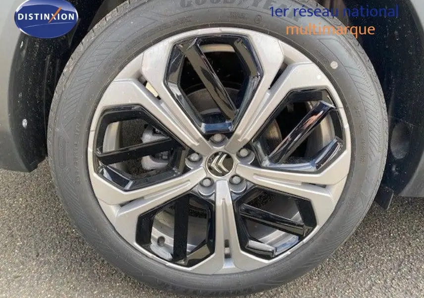 Gros plan sur la jante bi-ton gris et noir avec logo Citroën, roue avant droite d'une C5 X gris platinium.