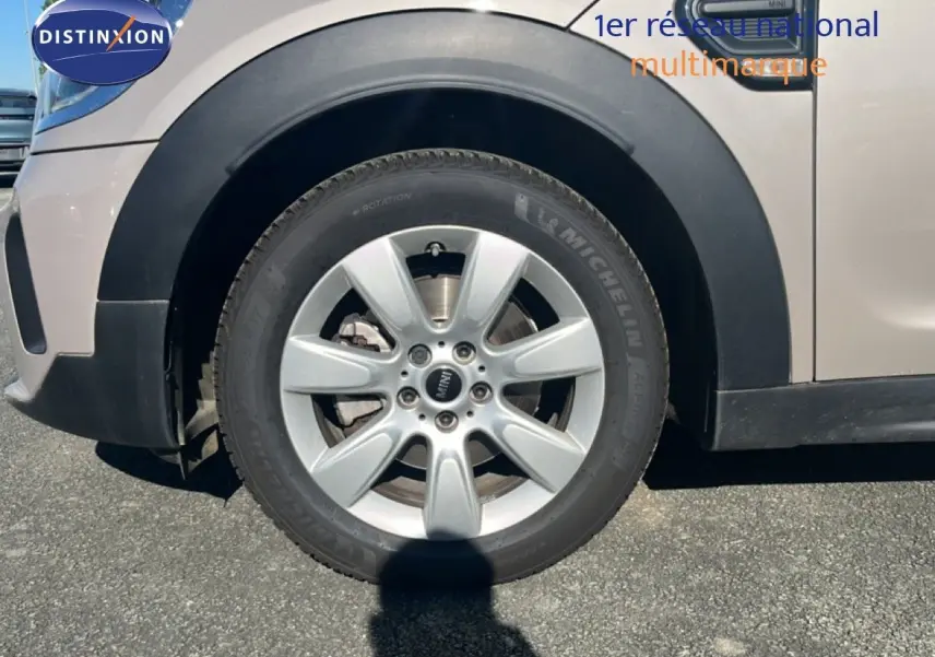 Gros plan sur la roue avant gauche d'une MINI Countryman grise Rooftop avec jante alliage 5 branches.