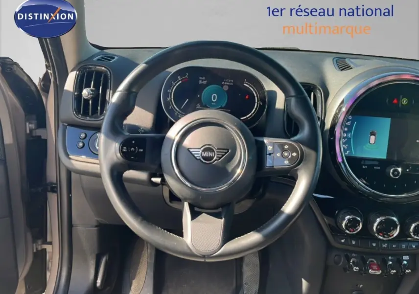 Vue intérieure centrée sur le volant du MINI Countryman 2023, tableau de bord numérique et écran tactile circulaire.
