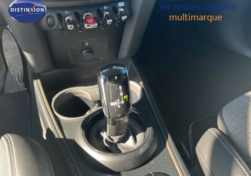 Gros plan sur la console centrale d’une MINI Countryman 2023, levier de boîte auto noir et détails des commandes.