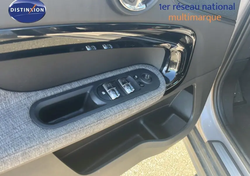 Détail de la porte avant gauche de la MINI Countryman 2023 en Rooftop Grey, avec commandes de vitres et tissu gris.