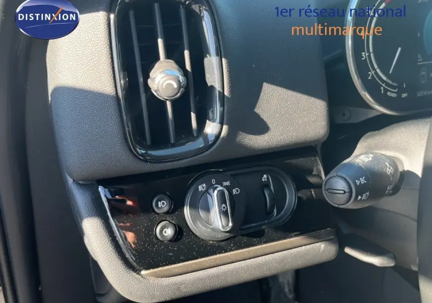 Détail du tableau de bord côté gauche du MINI Countryman Cooper 2023 avec commandes d’éclairage et aérateur noir.
