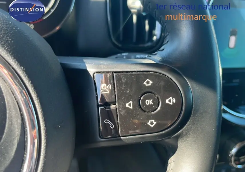 Gros plan sur les commandes au volant à droite du MINI Countryman 2023 en Rooftop Grey Metal, intérieur noir.