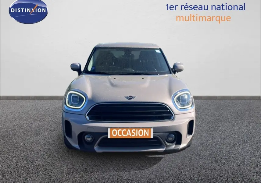 Vue frontale d'une MINI Countryman Cooper 2023 en gris rooftop avec phares LED allumés et plaque occasion.