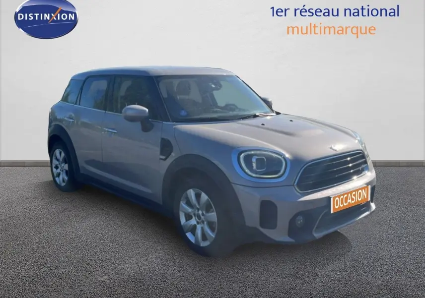Vue 3/4 avant d'une MINI Countryman Cooper grise rooftop, avec calandre noire et jantes argentées.