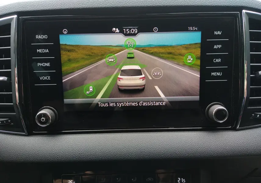 Écran central du Skoda Karoq gris 2021 montrant l'interface des systèmes d'assistance à la conduite.