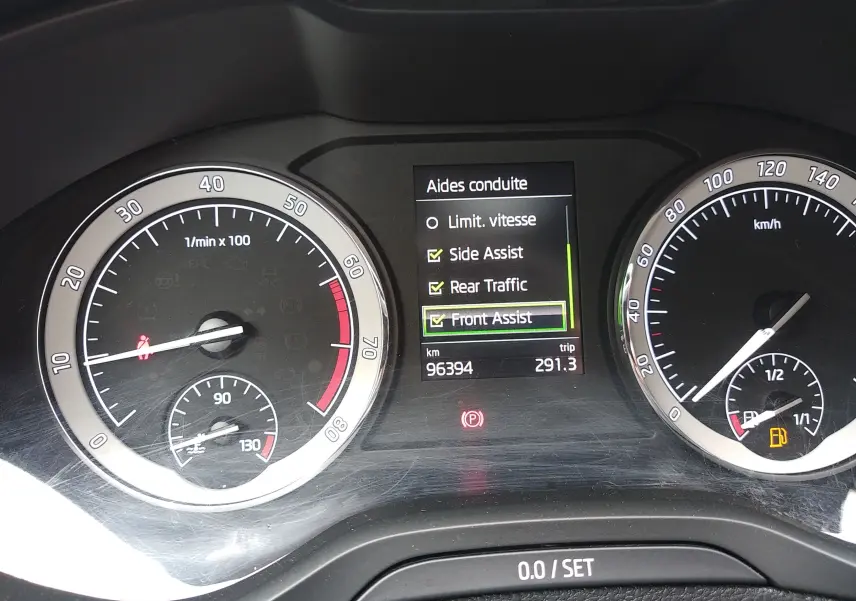 Tableau de bord du Skoda Karoq gris 2021, affichant les aides à la conduite et compteurs vitesse et régime moteur.