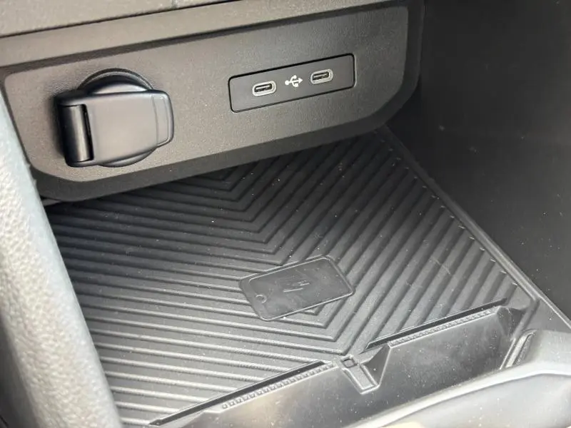 Gros plan sur la zone de recharge et ports USB noirs dans l'habitacle du Dacia Bigster blanc 2025.