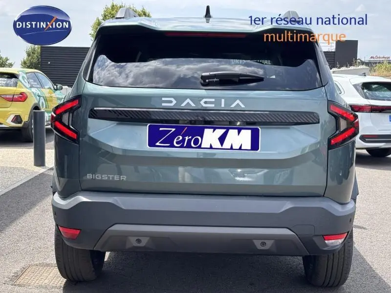 Vue arrière d'un Dacia Bigster blanc avec feux arrière LED et logo DACIA bien visible sur le hayon.