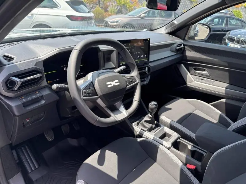 Vue intérieure côté conducteur du Dacia Bigster 2025 avec volant multifonction, écran tactile et boîte manuelle.