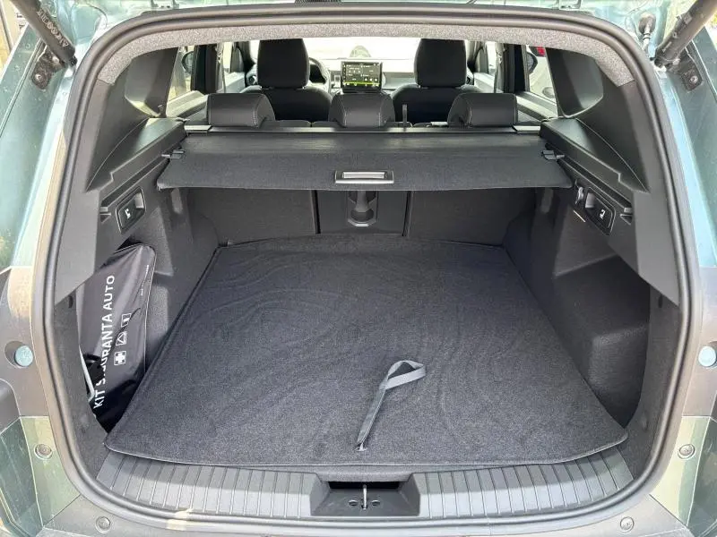 Coffre ouvert du Dacia Bigster blanc, vue arrière montrant la tablette cache bagages et l'espace de rangement noir.