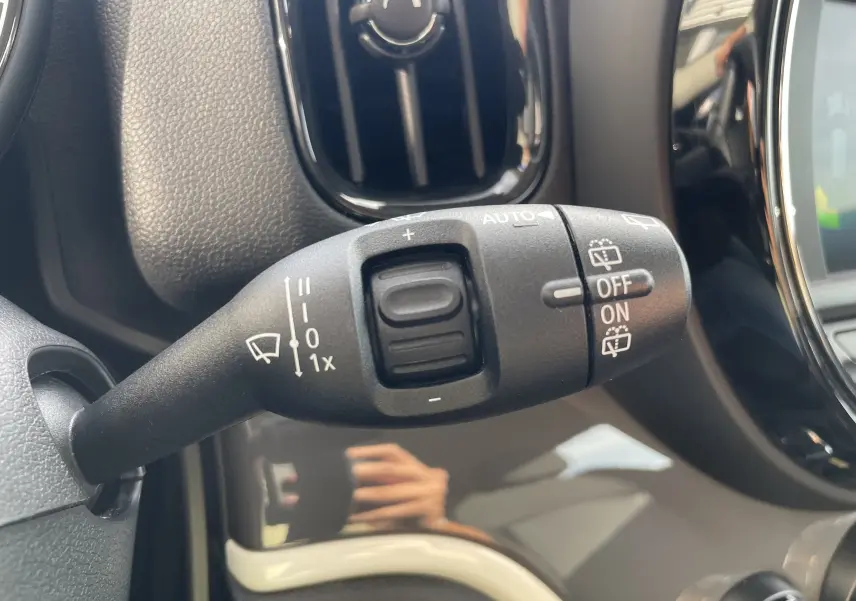 Gros plan sur la commande d'essuie-glace à gauche du volant dans l'habitacle gris noir du MINI Countryman Moonwalk Grey.