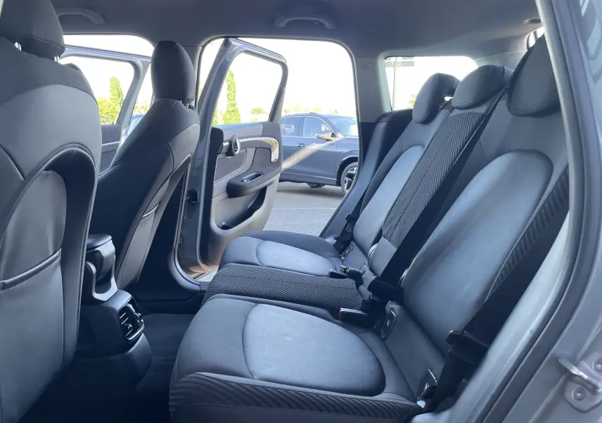 Vue intérieure côté droit sur les sièges arrière gris noir d'une MINI COUNTRYMAN F60 Moonwalk Grey avec porte ouverte.