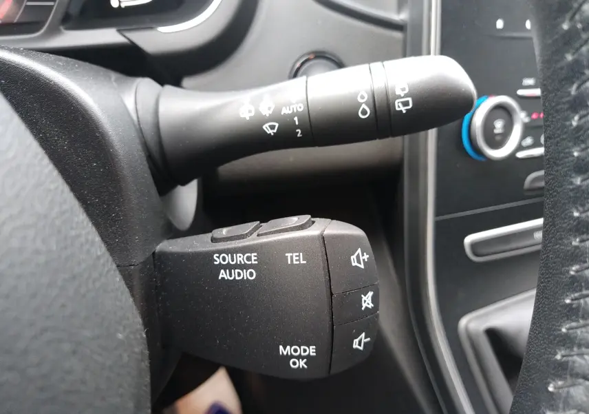 Gros plan sur la commande audio et téléphone à gauche du volant du Renault Grand Scenic brun vison 2018, intérieur noir.