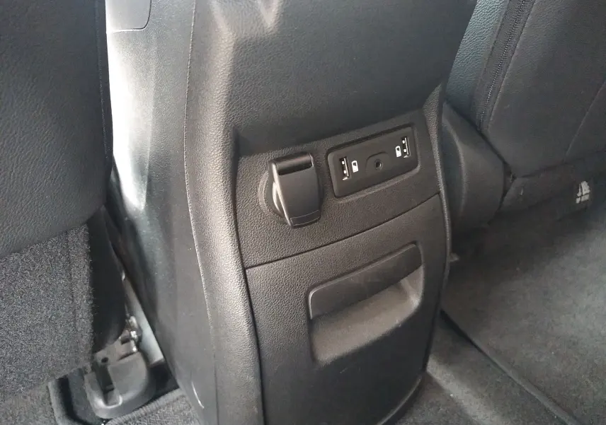 Prise USB et prise 12V en gros plan sur la console arrière d'un Renault Grand Scenic brun vison métal.