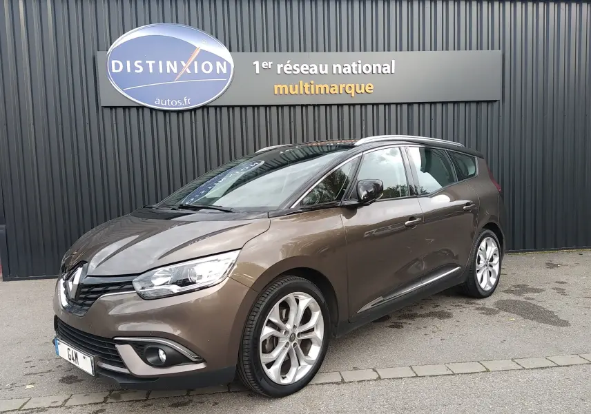 Renault Grand Scenic brun vison métal avec toit noir, vue 3/4 avant droit, garé devant un mur noir avec enseigne Distinxion.