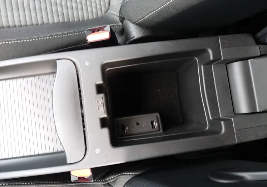 Vue rapprochée de la console centrale noire du Renault Grand Scenic IV avec ports USB et accoudoir entre les sièges avant.
