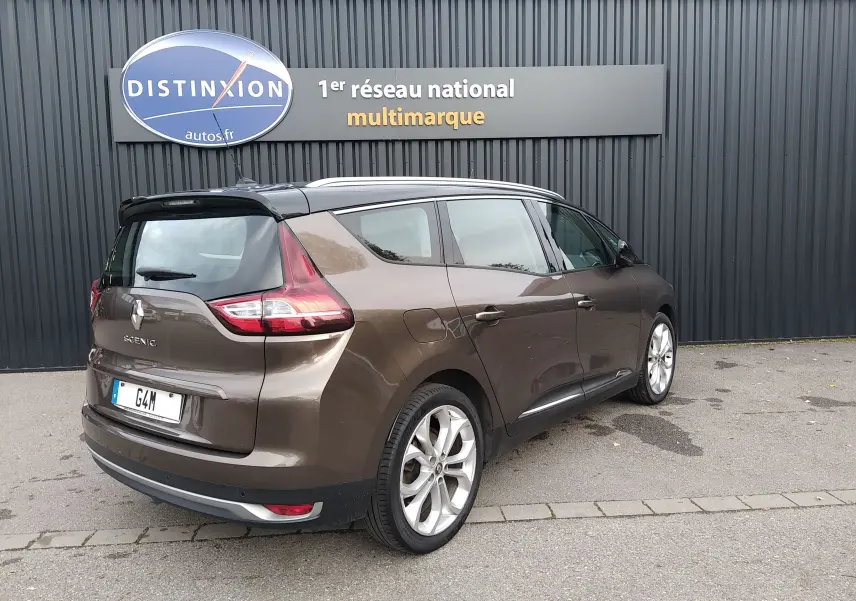 Renault Grand Scenic brun vison métal avec toit noir, vue 3/4 arrière droit, stationné devant un mur noir.