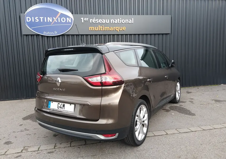 Renault Grand Scenic brun vison métal avec toit noir, vue 3/4 arrière droit, stationné devant un mur gris.