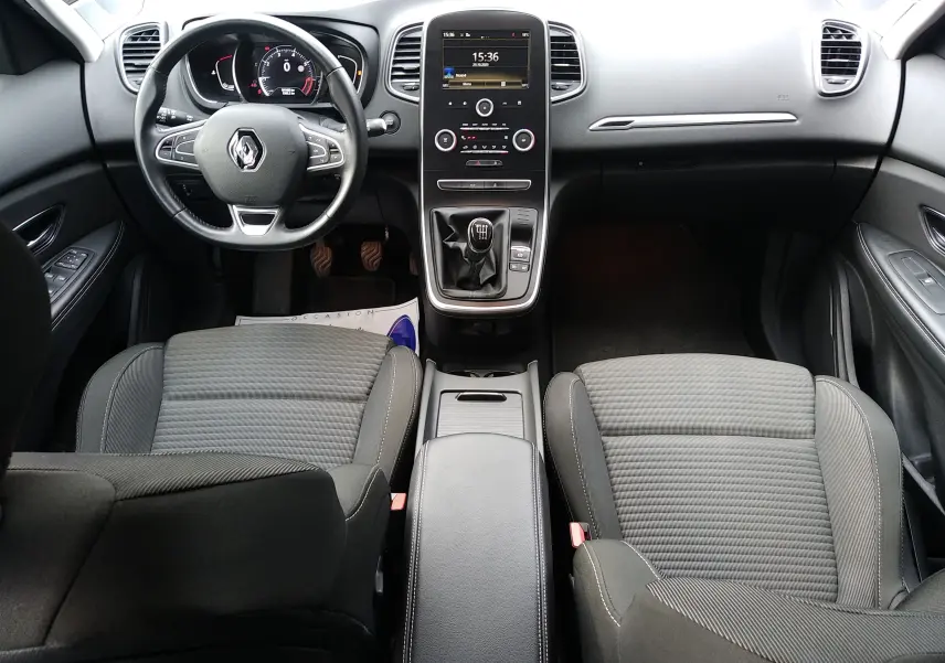 Vue intérieure avant du Renault Grand Scenic IV avec volant multifonction, console centrale tactile et sièges tissu gris.