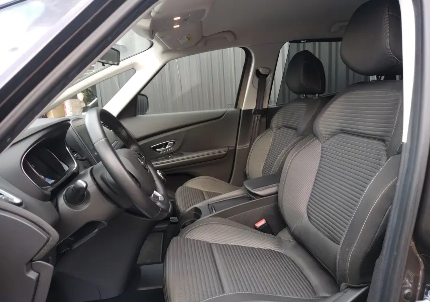 Vue intérieure côté conducteur du Renault Grand Scenic IV 2018, sièges tissu gris et tableau de bord sobre.