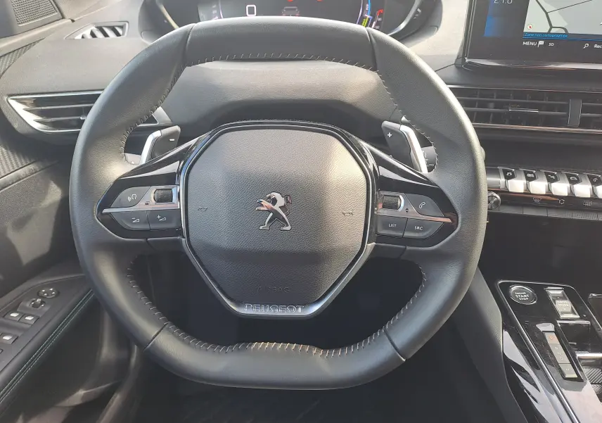 Volant cuir noir de Peugeot 3008 Hybrid 145 Allure Pack 2024 avec commandes intégrées et tableau de bord numérique.
